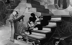 A Black And White Cartoon Of Mickey Mouse Sitting On A Set Of Stairs Next To A Skeleton . GIF
