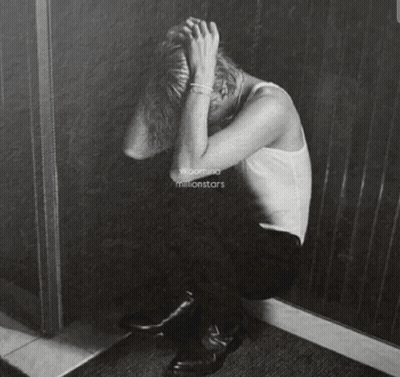 A Black And White Painting Of A Person Covering Their Face GIF