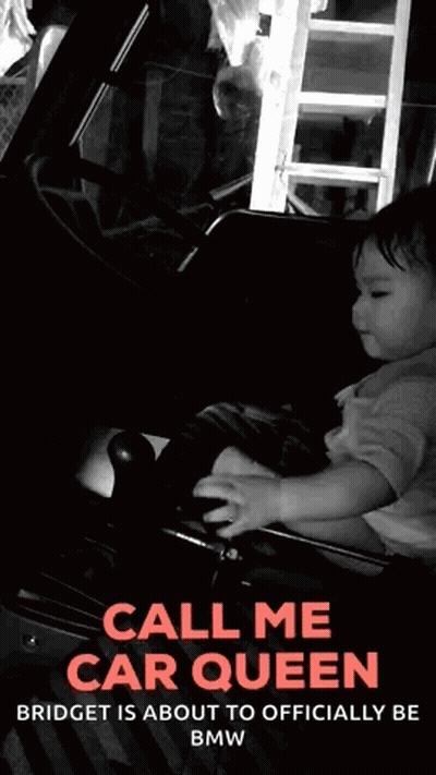 A Black And White Photo Of A Baby Holding A Steering Wheel With The Words Call Me Car Queen GIF