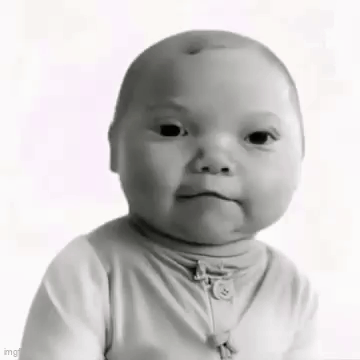 a black and white photo of a baby making a funny face while looking at the camera .