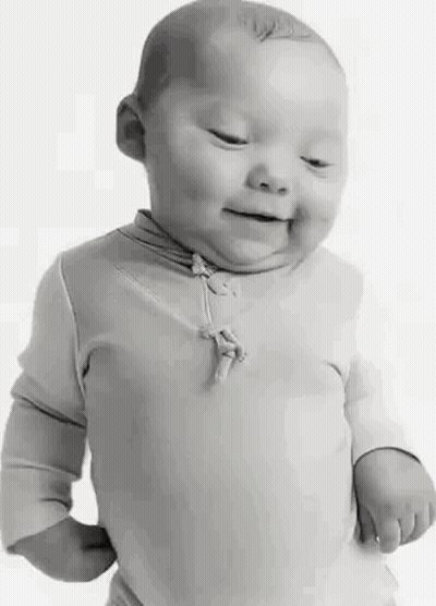 A Black And White Photo Of A Baby With Down Syndrome Smiling . GIF