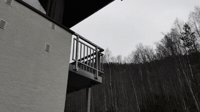 A Black And White Photo Of A Balcony Overlooking Trees GIF