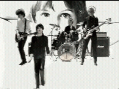 A Black And White Photo Of A Band Playing Instruments On A Stage . GIF