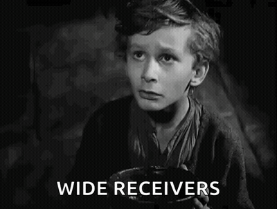 A Black And White Photo Of A Boy Holding A Bowl That Says I Want Some More GIF