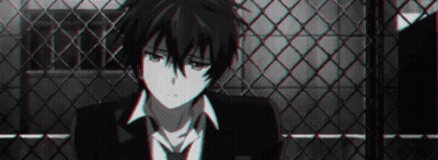 A Black And White Photo Of A Boy In A Suit And Tie Sitting In Front Of A Chain Link Fence . GIF