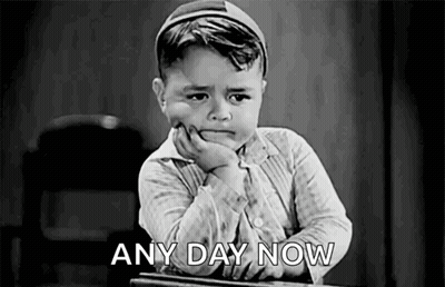 A Black And White Photo Of A Boy Sitting At A Desk With His Hand On His Chin And The Words `` Any Day Now '' . GIF