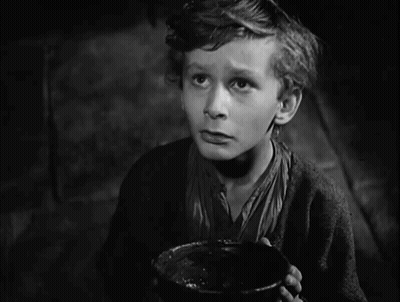 A Black And White Photo Of A Boy With The Words I Want Some More Above Him GIF
