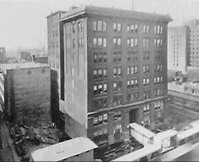 A Black And White Photo Of A Building With A Lot Of Windows GIF