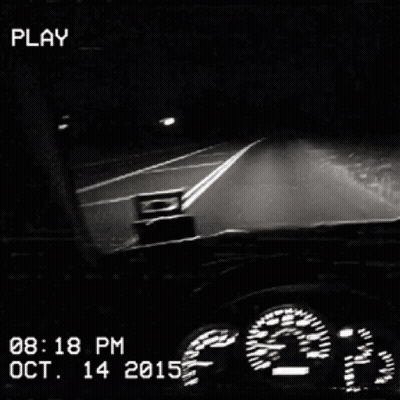 A Black And White Photo Of A Car Driving Down A Highway At Night GIF