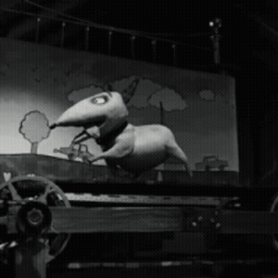 A Black And White Photo Of A Cartoon Dog On A Cart GIF