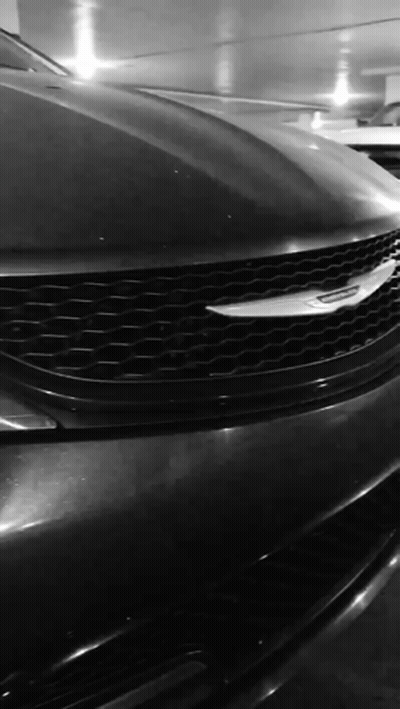 A Black And White Photo Of A Chrysler Car In A Parking Garage GIF