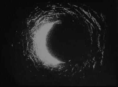 A Black And White Photo Of A Circle In The Dark . GIF