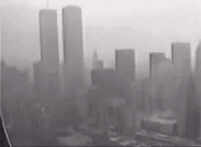 A Black And White Photo Of A City Skyline With A Few Buildings In The Distance . GIF