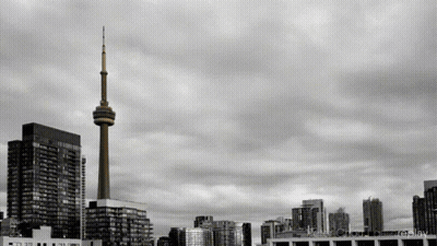 A Black And White Photo Of A City Skyline With A Tower In The Middle GIF