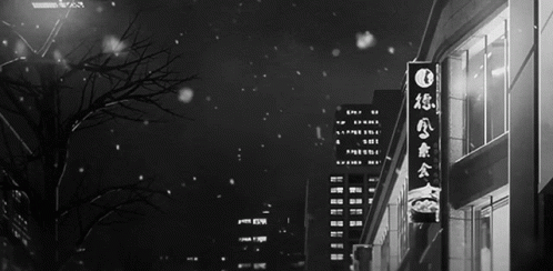 A Black And White Photo Of A City Street With Chinese Writing On A Sign GIF