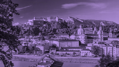 A Black And White Photo Of A City With A Castle On Top Of A Hill GIF