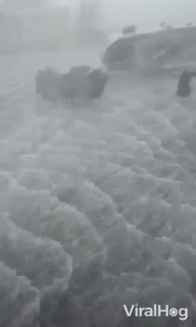 A Black And White Photo Of A Cloudy Sky Taken From An Airplane . GIF