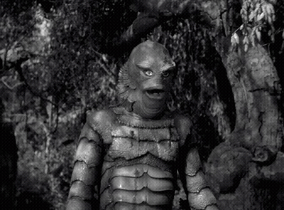 A Black And White Photo Of A Creature From The Black Lagoon Standing In The Woods . GIF