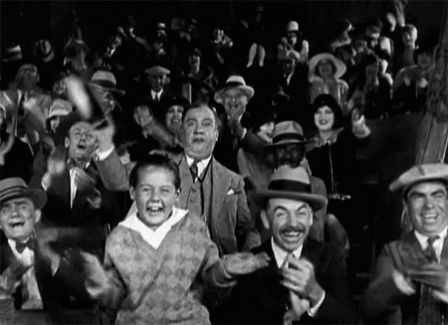 A Black And White Photo Of A Crowd Of People GIF