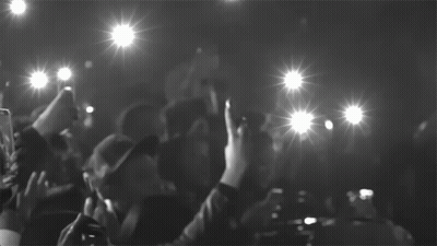 A Black And White Photo Of A Crowd Taking Pictures With Their Cell Phones GIF