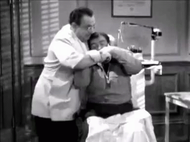 A Black And White Photo Of A Dentist Examining A Patient . GIF