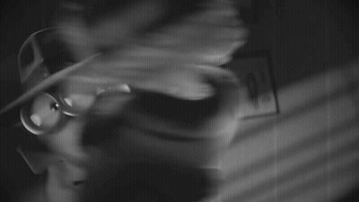 A Black And White Photo Of A Doll Wearing A Hat GIF