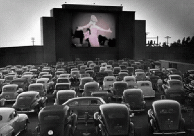 A Black And White Photo Of A Drive-In Theater GIF