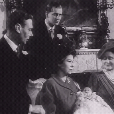 A Black And White Photo Of A Family With A Baby In The Middle GIF