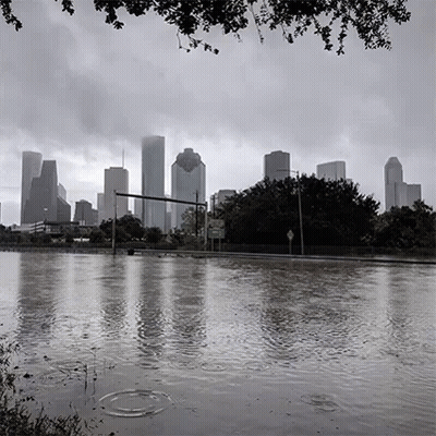 A Black And White Photo Of A Flooded City With The Skyline In The Background . GIF