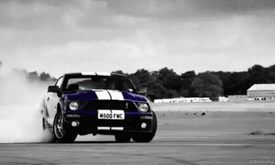 A Black And White Photo Of A Ford Mustang Drifting On A Track GIF