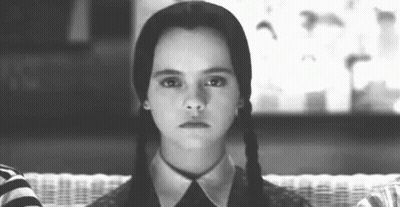 A Black And White Photo Of A Girl With Pigtails Making A Face . GIF