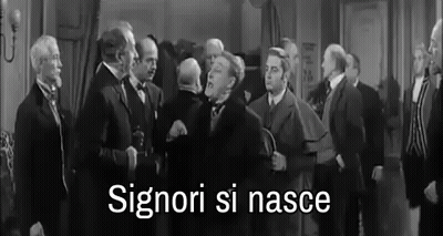 A Black And White Photo Of A Group Of Men Standing In A Room With The Words Signori Si Nasce Written In White . GIF