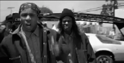 A Black And White Photo Of A Group Of Men Standing Next To A Car . GIF