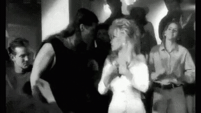 A Black And White Photo Of A Group Of People Dancing In A Room . GIF