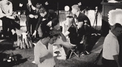 A Black And White Photo Of A Group Of People Sitting In A Circle . GIF