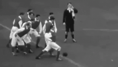 A Black And White Photo Of A Group Of People Walking On A Field . GIF