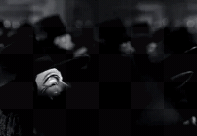 A Black And White Photo Of A Group Of People Wearing Anonymous Masks . GIF