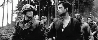 A Black And White Photo Of A Group Of Soldiers In A Forest . GIF