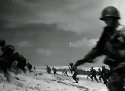 A Black And White Photo Of A Group Of Soldiers Running On A Beach . GIF