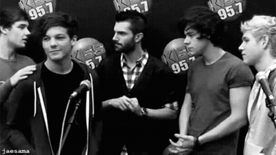 A Black And White Photo Of A Group Of Young Men Shaking Hands . GIF