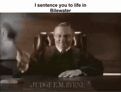 A Black And White Photo Of A Judge Sitting At A Desk With A Gavel In Front Of Him . GIF