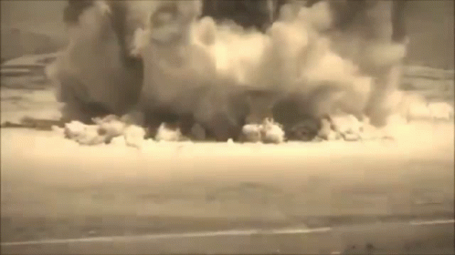 A Black And White Photo Of A Large Explosion With Smoke Coming Out Of It GIF