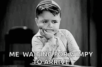 A Black And White Photo Of A Little Boy Sitting At A Desk . GIF