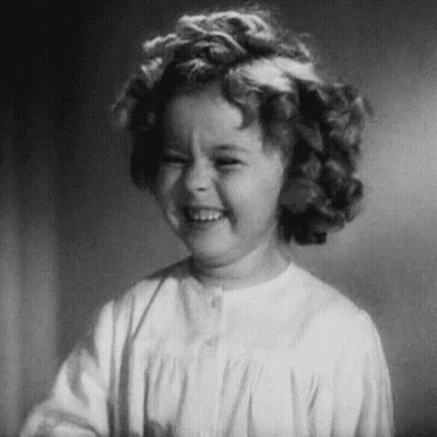 A Black And White Photo Of A Little Girl Laughing . GIF
