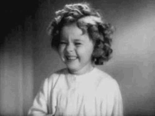 A Black And White Photo Of A Little Girl Laughing . GIF