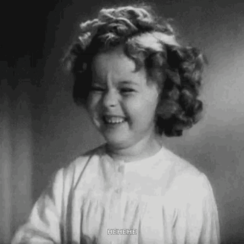 A Black And White Photo Of A Little Girl Laughing With Her Mouth Open . GIF