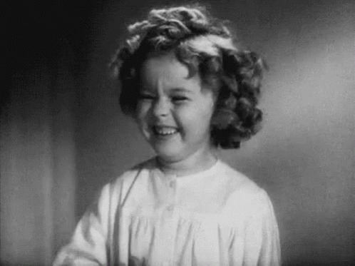A Black And White Photo Of A Little Girl Smiling . GIF