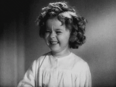 A Black And White Photo Of A Little Girl Smiling . GIF