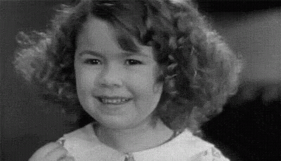 A Black And White Photo Of A Little Girl Smiling . GIF