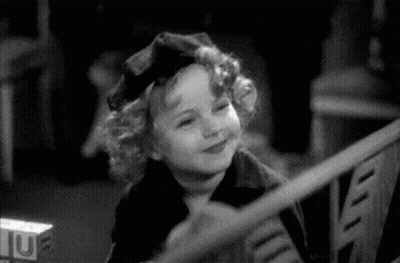 A Black And White Photo Of A Little Girl Wearing A Hat . GIF
